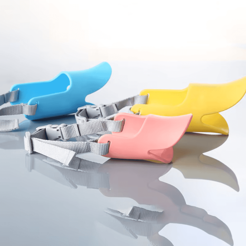 Dogs Anti Bite Stop muzzles in blue, yellow, and pink with adjustable straps. Made from soft silicone for pet comfort and safety.